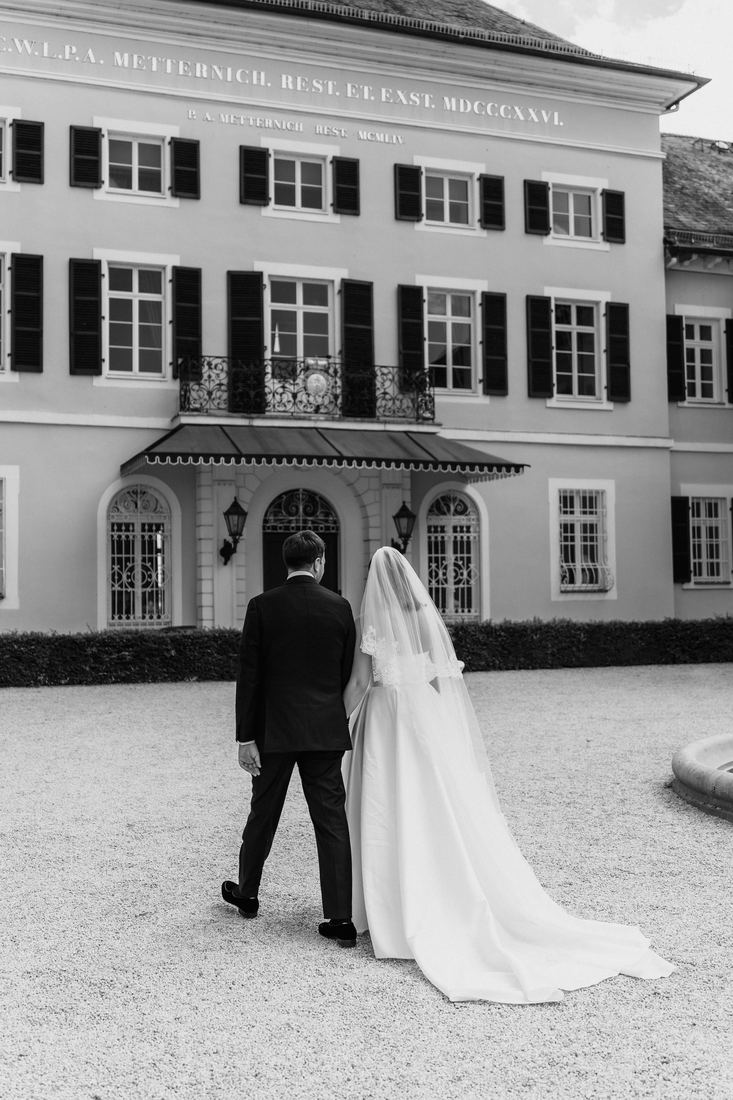Brautpaar auf dem Weg zum Empfang vor dem Schloss